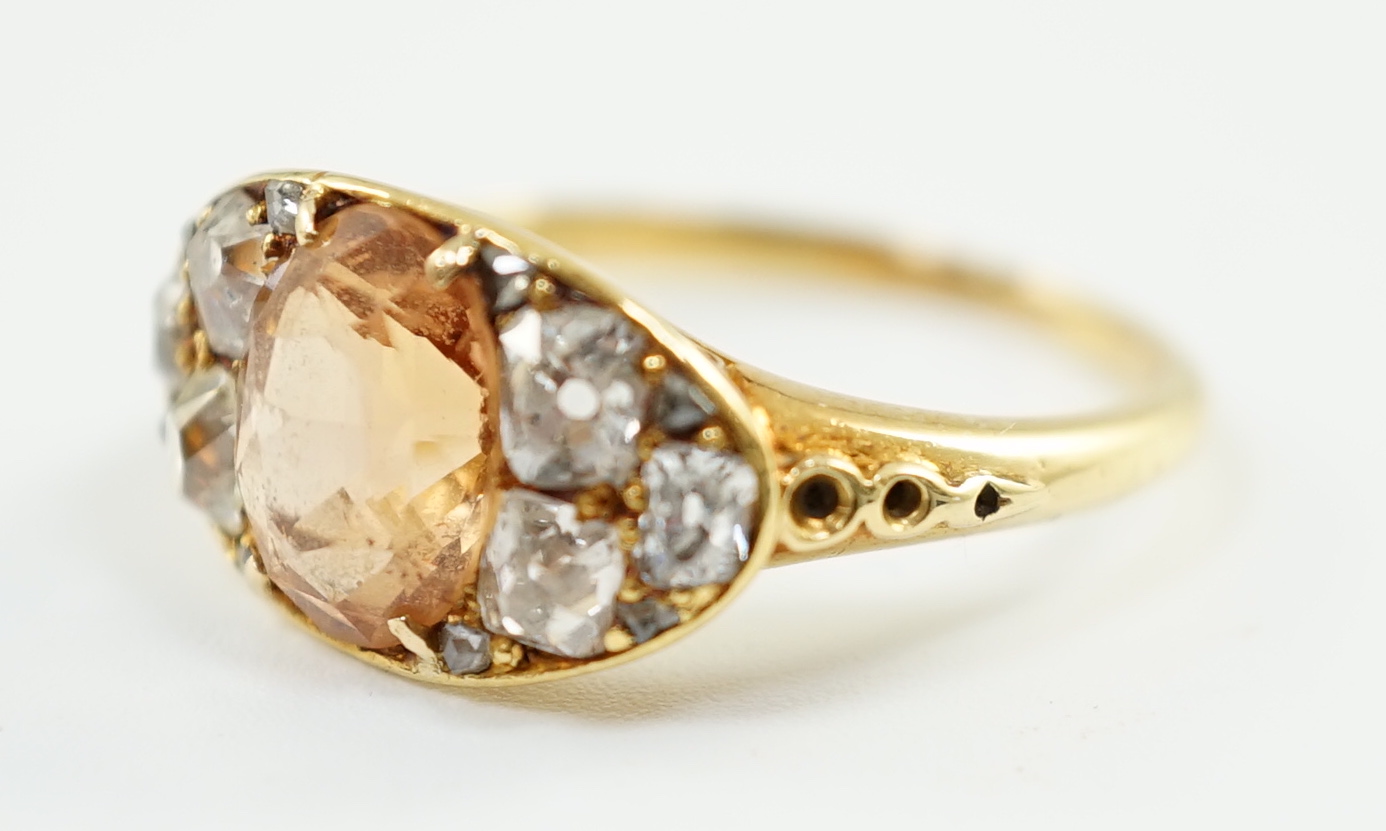 A 1940's gold and single stone oval cut orange topaz set ring, with six stone old mine cut diamond set shoulders